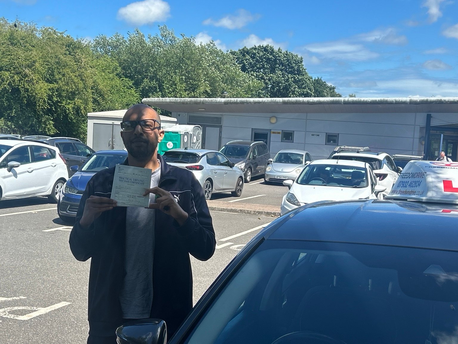 Akram Abdalla holding a driving test pass certificate
